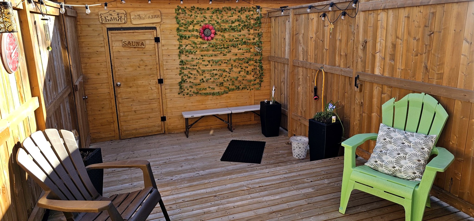 Sauna entrance door with carved Banya, Laznya and Sauna signs and an ivy-decorated wall